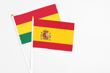 Spain and Ghana stick flags on white background. High quality fabric, miniature national flag. Peaceful global concept.White floor for copy space.