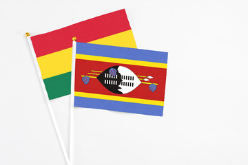 Swaziland and Ghana stick flags on white background. High quality fabric, miniature national flag. Peaceful global concept.White floor for copy space.
