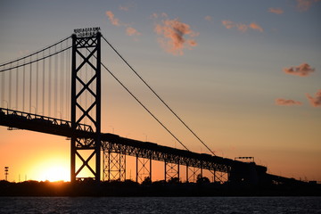 Ambassador Bridge between Detroit, Michigan and Windsor, Ontario. Sunset on the Detroit River with the silhouette of the bridge. Border crossing between the US and Canada