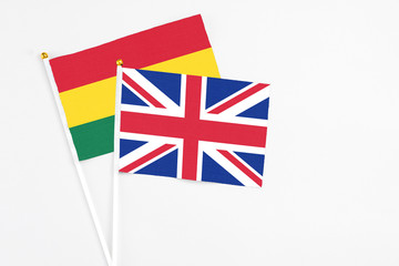 United Kingdom and Ghana stick flags on white background. High quality fabric, miniature national flag. Peaceful global concept.White floor for copy space.