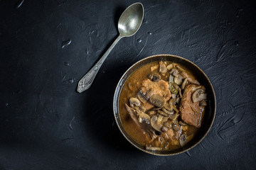 Stewed pork chop in a bright mushroom sauce.
