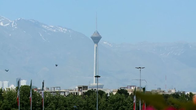 TEHRAN, IRAN - 2013: Birds fly in front of Milad Tower in Tehran, Iran. Milad Tower, also known as Tehran Tower, is one of the tallest in the world and a prominent landmark of Tehran