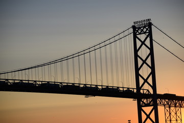 Ambassador Bridge between Detroit, Michigan and Windsor, Ontario. Sunset on the Detroit River with the silhouette of the bridge. Border crossing between the US and Canada