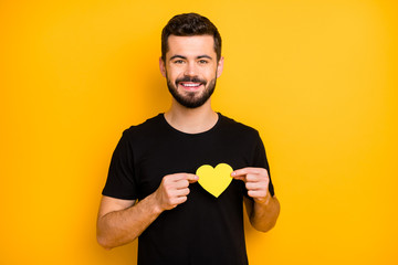 Portrait of charming bearded lover man have 14-february dating with his girlfriend show yellow paper card heart near chest wear casual style clothing isolated over vibrant color background