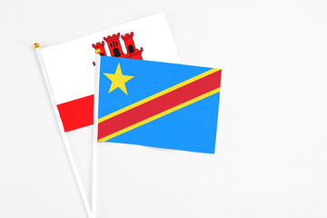 Congo and Gibraltar stick flags on white background. High quality fabric, miniature national flag. Peaceful global concept.White floor for copy space.