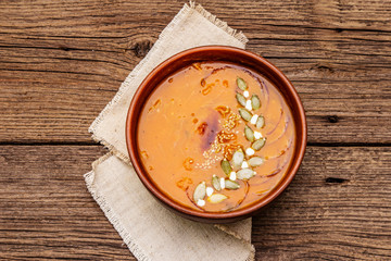 Autumn pumpkin cream soup. Traditional ingredients, healthy food concept. Napkin, vintage wooden background