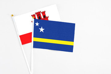 Curacao and Gibraltar stick flags on white background. High quality fabric, miniature national flag. Peaceful global concept.White floor for copy space.