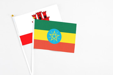 Ethiopia and Gibraltar stick flags on white background. High quality fabric, miniature national flag. Peaceful global concept.White floor for copy space.