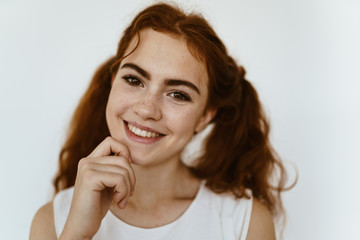 Fototapeta premium schoolgirl with a happy smile holds on to her chin. light background