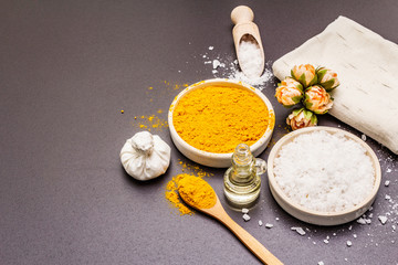 Personal care with natural ingredients. Healthy spa concept. Turmeric, sea salt, oil, towel. Stone concrete background