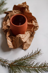 ceramic mug clay red on light marble background top view on Kraft paper and fir branches