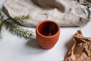ceramic mug clay red on light marble background top view on Kraft paper and fir branches