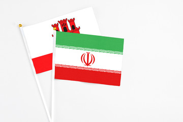 Iran and Gibraltar stick flags on white background. High quality fabric, miniature national flag. Peaceful global concept.White floor for copy space.