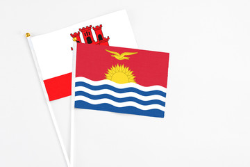 Kiribati and Gibraltar stick flags on white background. High quality fabric, miniature national flag. Peaceful global concept.White floor for copy space.