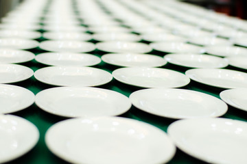 The white dish are beautifully arranged on the green table top.