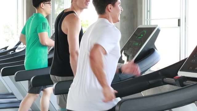 a group of sporty caucasian people exercising with running machine back view image