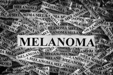 Torn pieces of paper with the words Melanoma