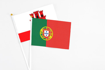 Portugal and Gibraltar stick flags on white background. High quality fabric, miniature national flag. Peaceful global concept.White floor for copy space.