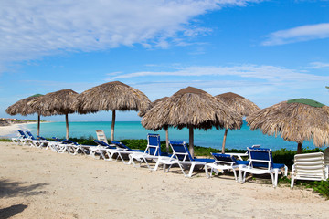 Naklejka na ściany i meble Deserted beautiful beach in the off-season with canopies of palm leaves.Horizontally.