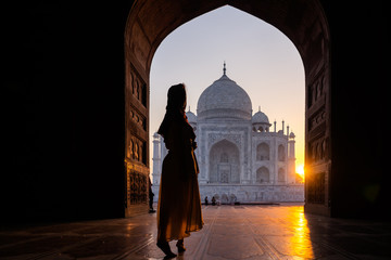 Young women stepping into the Taj Mahal,  sunrise view in Agra India 