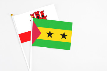 Sao Tome And Principe and Gibraltar stick flags on white background. High quality fabric, miniature national flag. Peaceful global concept.White floor for copy space.