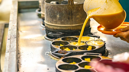 Fototapeta na wymiar cookie dough that is being poured into cake molds for cooking. Indonesia traditional mud cake