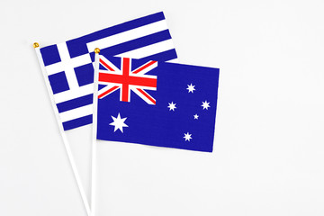 Australia and Greece stick flags on white background. High quality fabric, miniature national flag. Peaceful global concept.White floor for copy space.