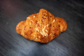 Croissant on a dark wooden background. Photographed close-up.
