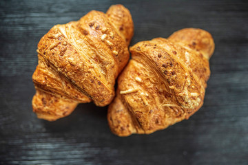 Croissant on a dark wooden background. Photographed close-up.