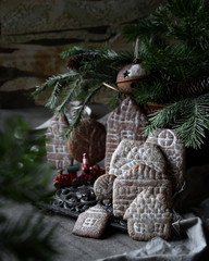 food photography of of christmas cookies gingerbread houses side view with decorations, spruce branches in vintage style close up