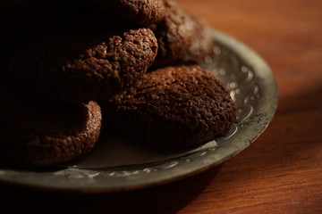 Oatmeal cookies in a silver vintage plate on a wooden table.