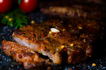  Sliced ​​ Piglet steak. Succulent meat of piglet on black marble background.