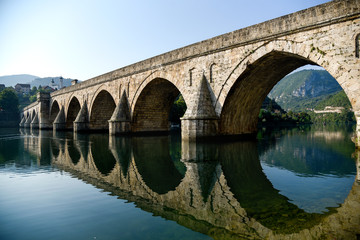 Fototapeta premium The Ottoman Mehmed Pasa Sokolovic Bridge in Visegrad, river reflection. Bosnia and Herzegovina.