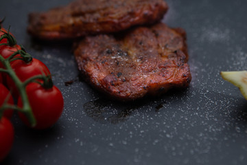  Sliced ​​ Piglet steak. Succulent meat of piglet on black marble background.