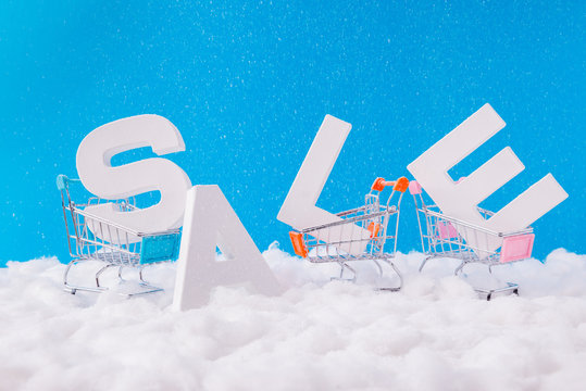 X-mas big season shopping sales concept. Photo of letters word sales stand under blue sky background in small supermarket mall center trolleys need buyers sellers carrying purchases