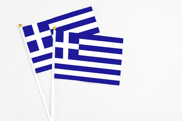 Greece and Greece stick flags on white background. High quality fabric, miniature national flag. Peaceful global concept.White floor for copy space.