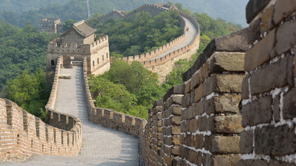 Fototapeta na wymiar The path of the great wall zigzagging through the mountain and crossing several guard posts. Mutianyu section, Beijing, China.