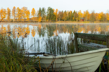 Beautiful autumn morning landscape with old rowing boat and Kymijoki river waters. Finland, Kymenlaakso, Kouvola