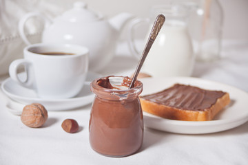 Bread toast with chocolate cream butter, cup of coffee on the white background