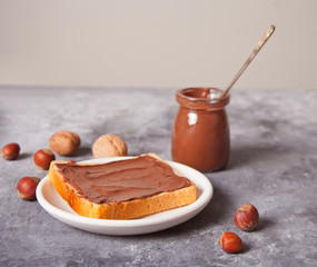 Bread toast with chocolate cream butter on the concrete background