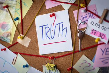 Truth search concept. Close-up view of a detective board with evidence. In the center is a white sheet attached with a red pin with the text Truth