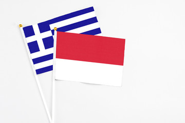 Monaco and Greece stick flags on white background. High quality fabric, miniature national flag. Peaceful global concept.White floor for copy space.