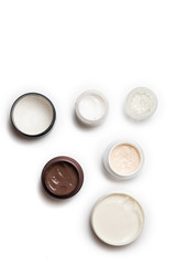 Care products for face, hands and body. Cream in jars on white background