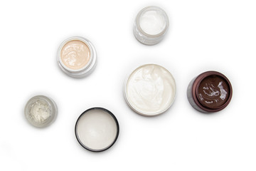 Care products for face, hands and body. Cream in jars on white background
