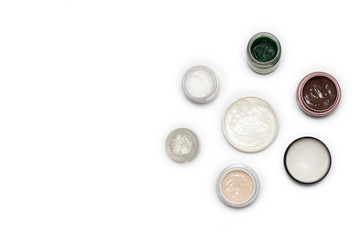 Care products for face, hands and body. Cream in jars on white background. Space for text