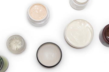 Care products for face, hands and body. Cream in jars on white background