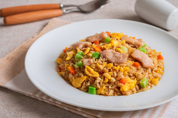 Fried rice chicken with egg and vegetables on white plate.