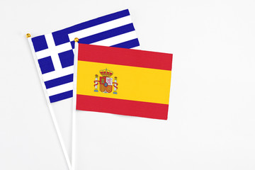 Spain and Greece stick flags on white background. High quality fabric, miniature national flag. Peaceful global concept.White floor for copy space.