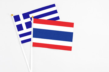 Thailand and Greece stick flags on white background. High quality fabric, miniature national flag. Peaceful global concept.White floor for copy space.