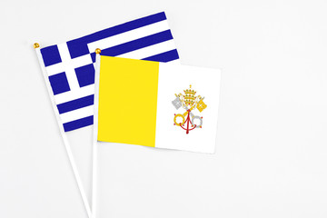 Vatican City and Greece stick flags on white background. High quality fabric, miniature national flag. Peaceful global concept.White floor for copy space.